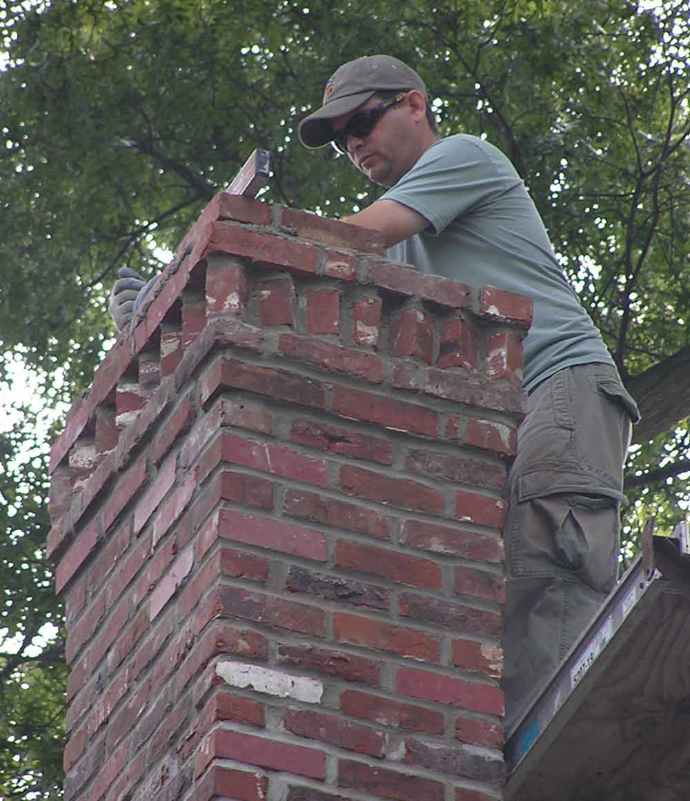 Mason's Chimney Service Original Photo of Chimney Lining Replacement technician working on a chimney lining replacement