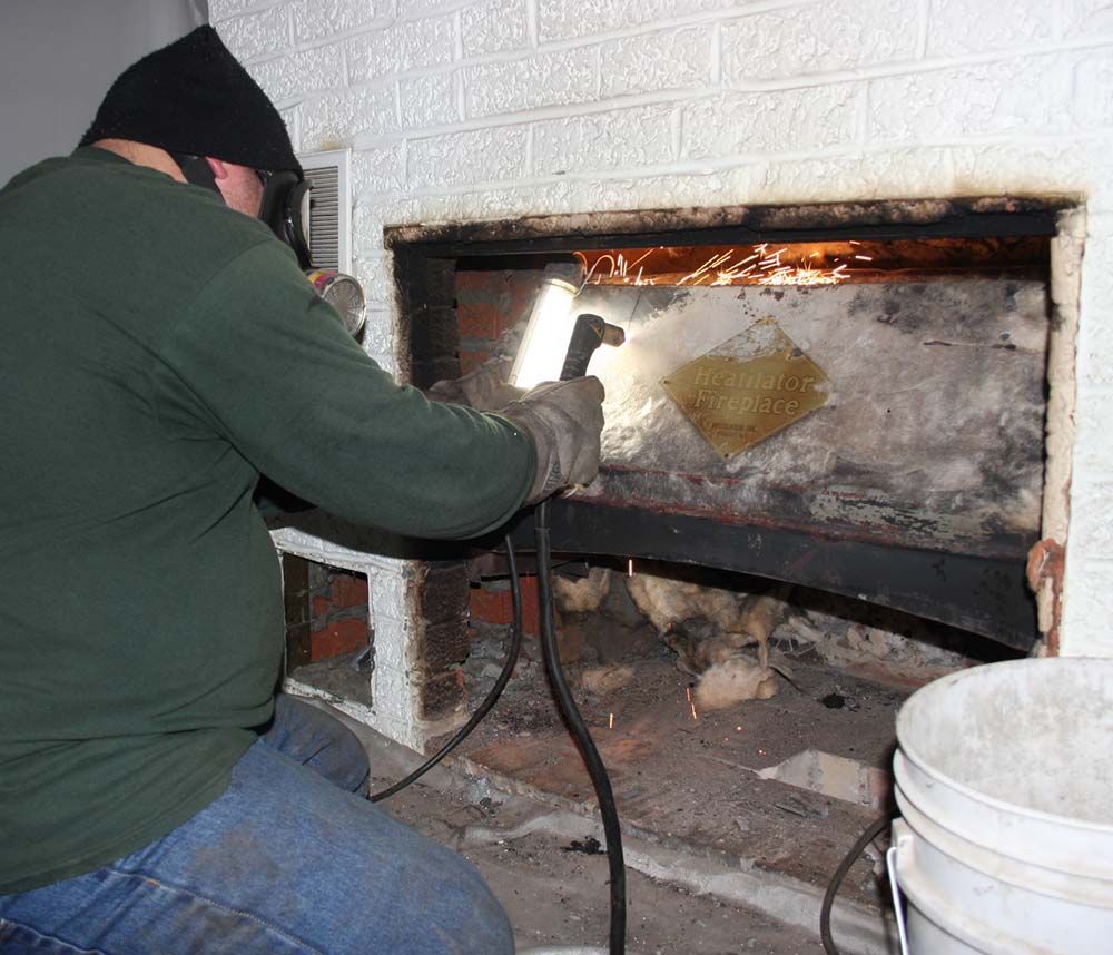 Mason's Chimney Service Original Photo of Firebox Repair technician working on firebox repair