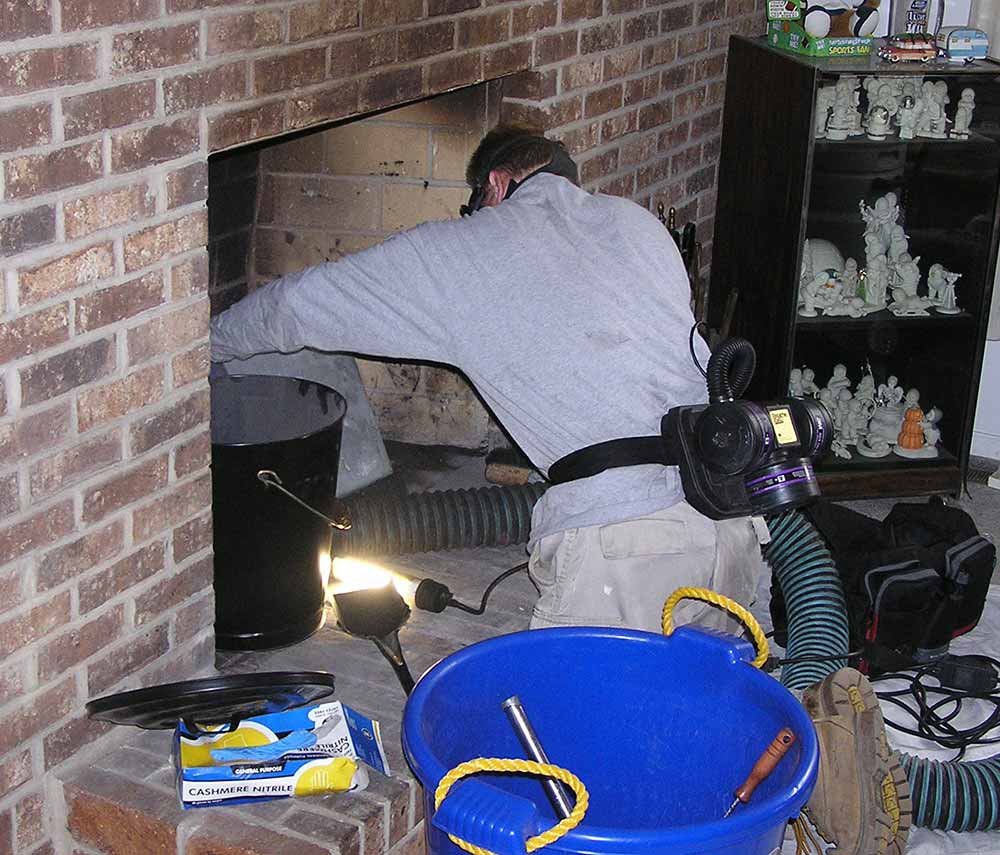 man cleaning fireplace