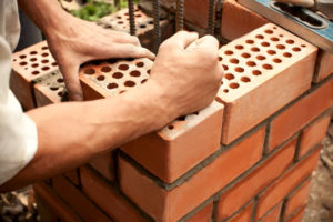 bricklayer laying masonry for a chimney