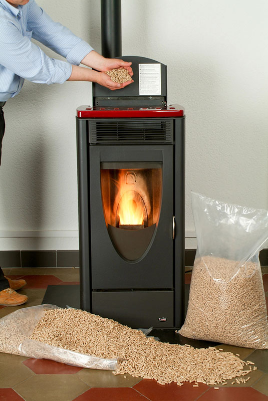 Mason's Chimney Service-Stock Image of pellet stove A man filling a stove with pellets